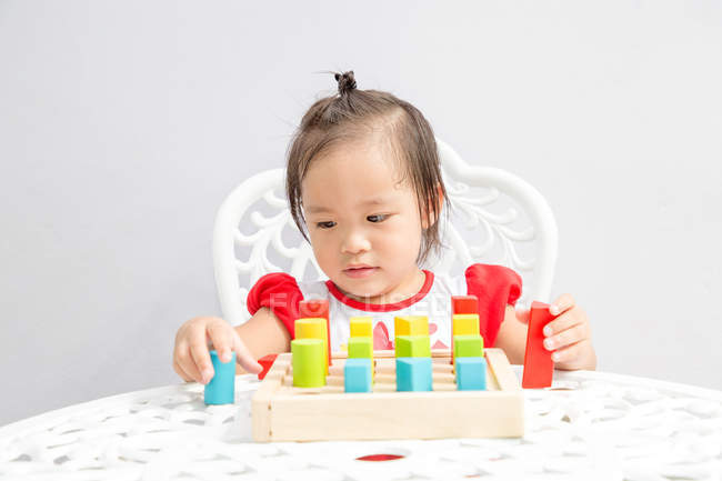 Маленькая азиатская девочка, играющая в образовательные игрушки — стоковое фото