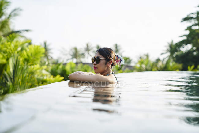 Young asian woman relaxing in a pool — Stock Photo
