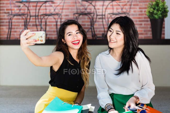 Жінки беруть selfies вздовж вулиці Орчард-роуд. — стокове фото
