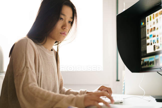 Mulher chinesa trabalhando em casa no computador — Fotografia de Stock