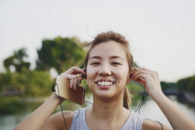 Молоді азіатські жінки прослуховування музики в earpods — стокове фото