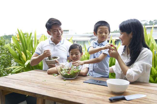 Glückliche asiatische Familie bereitet zu Hause gemeinsam Essen zu — Stockfoto