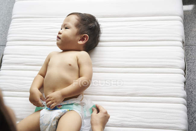 Mother changing diapers for her adorable baby boy — Stock Photo