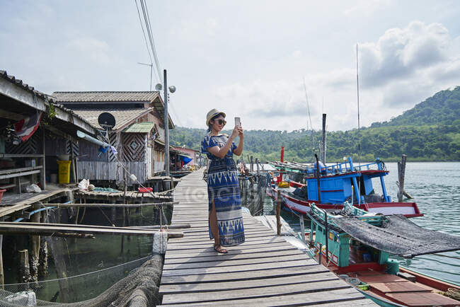 Mujer joven tomando fotos en Ban Ao Yai Fishing Village - foto de stock