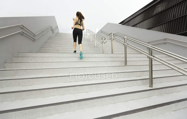 Молоді азіатські, жінка бігун підбігаючи сходи в Сінгапурі. — стокове фото