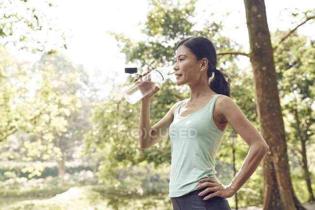 Mujer hidratante después de hacer ejercicio - foto de stock