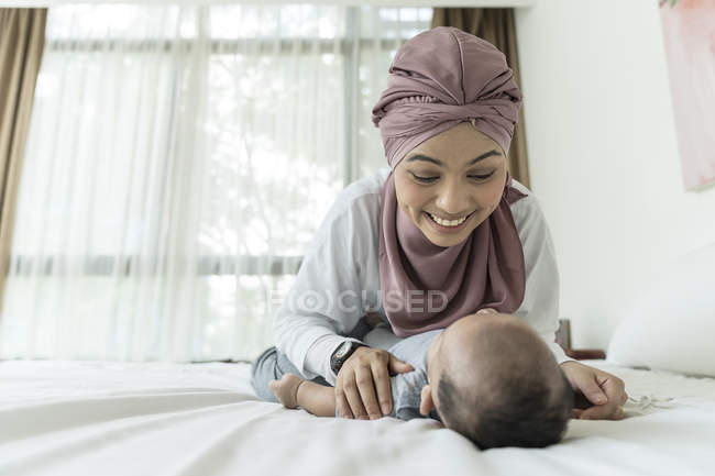 Mamma e bambino sdraiati sul letto a casa — Foto stock