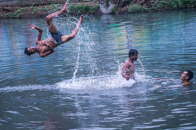 Akrobatische Vorführung von Kindern im Wasser. Spaß und Lachen unter Freunden — Stockfoto