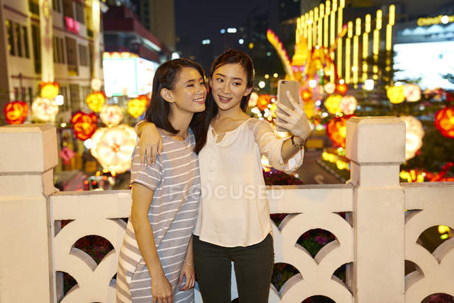 Jeunes amis asiatiques heureux passer du temps ensemble au Nouvel An chinois et de prendre selfie — Photo de stock