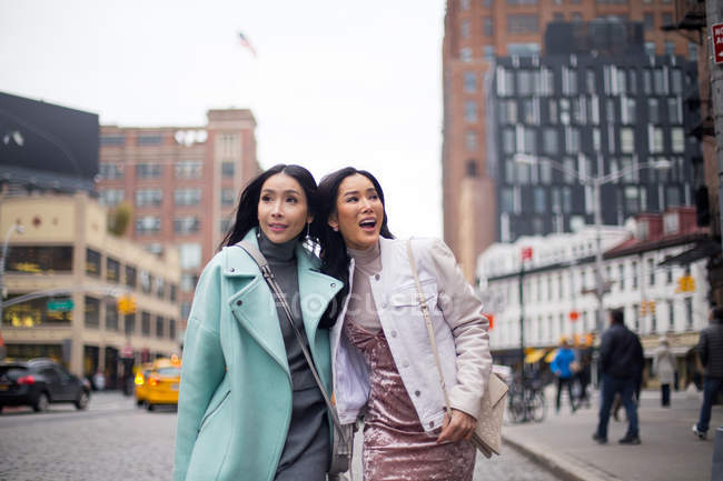 Two young asian woman walking at city — Stock Photo