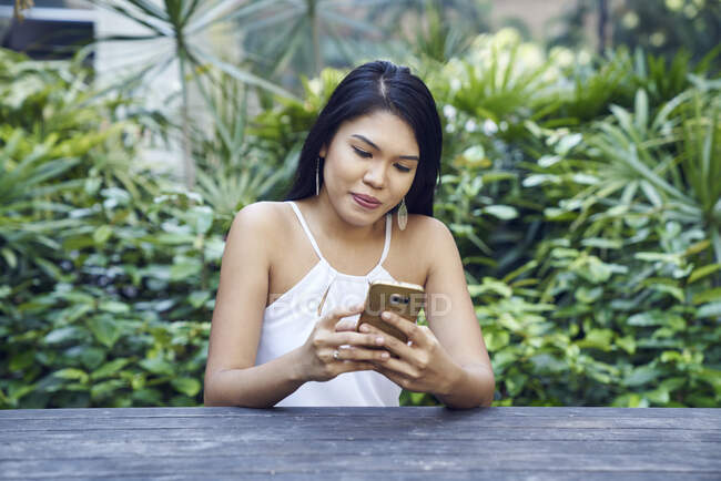 Hermosa dama malaya usando su móvil - foto de stock