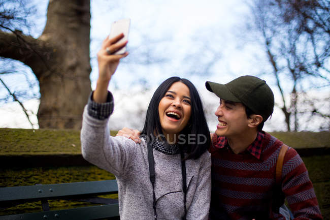 Young asian couple of tourists taking selfie in central park, New York, USA — Stock Photo