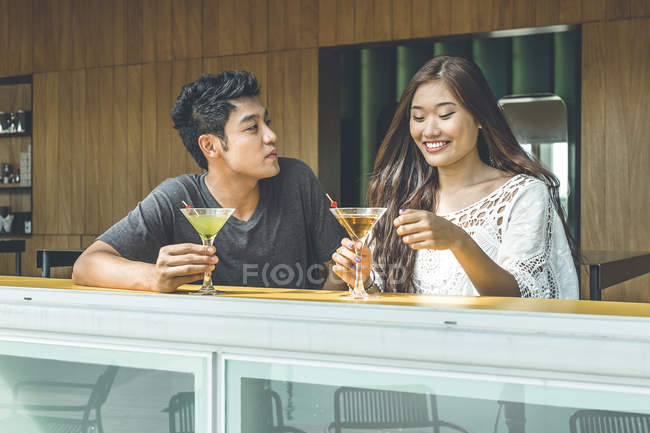 Couple having easy talk and drinks at Sentosa beach club — Stock Photo