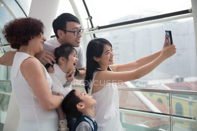 Uma família asiática de três gerações tira uma selfie em um shopping — Fotografia de Stock