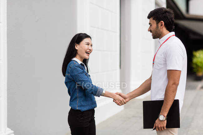 Male salesperson talking to woman outdoors — Stock Photo