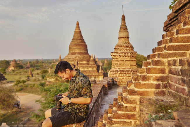 Молодой человек делает фото вокруг древнего храма Пятадар, Баган, Мьянма — стоковое фото