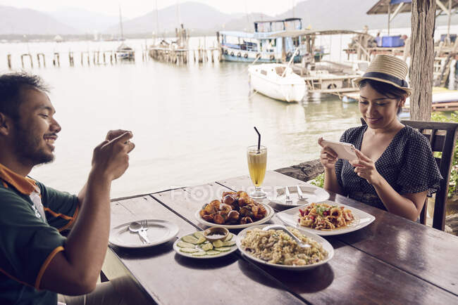 Jeune couple prenant des photos de leur nourriture à Koh Chang, Thaïlande — Photo de stock