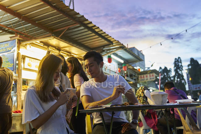 Feliz jovem asiático casal sentado juntos no rua café — Fotografia de Stock