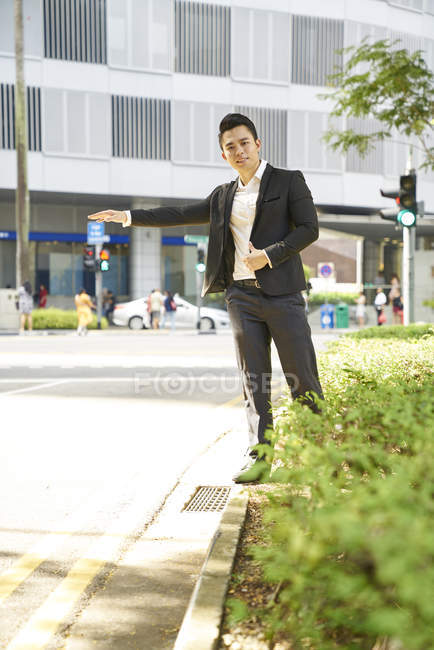 Молодий азіатський успішний бізнесмен спіймав таксі — стокове фото
