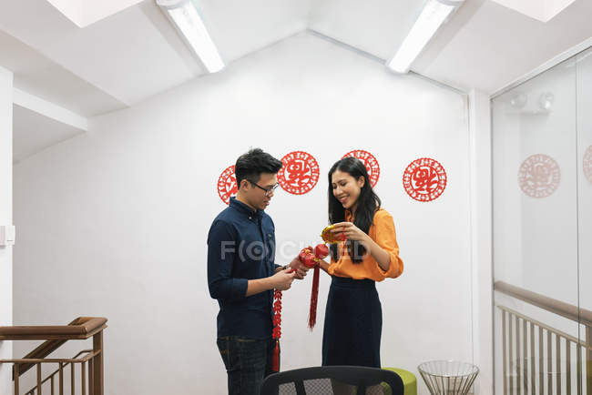 Young happy asian couple celebrating Chinese New Year together and decorating home — Stock Photo
