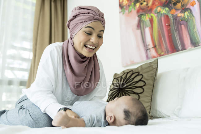 Мати і дитина лежать на ліжку вдома — стокове фото