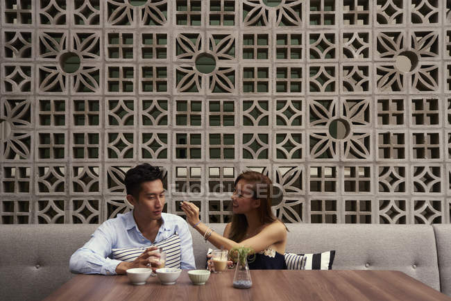 Young attractive asian couple together sitting in cafe — Stock Photo