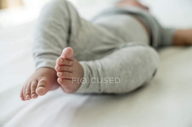 Babyfüße liegen zu Hause auf dem Bett — Stockfoto