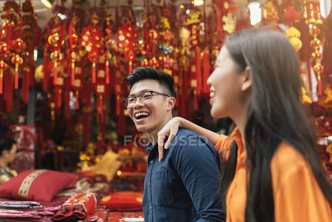 Young happy asian couple celebrating Chinese New Year together in Chinatown — Stock Photo