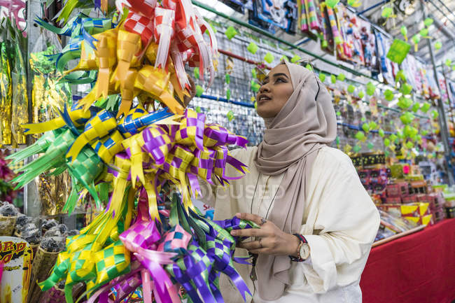 Eine muslimische Dame kauft Hari-Raya-Dekorationen. — Stockfoto