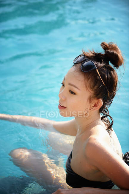 Closeup view of happy beautiful asian woman swimming in pool — Stock Photo