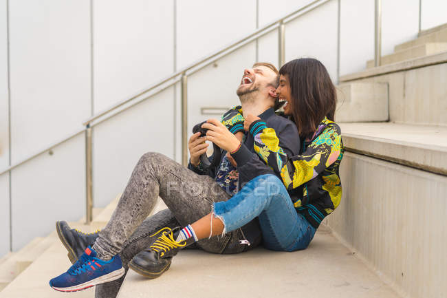 Jovem atraente casal multirracial sentado em escadas — Fotografia de Stock