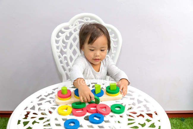 Joven poco asiático niño chica jugando con educativo juguetes - foto de stock