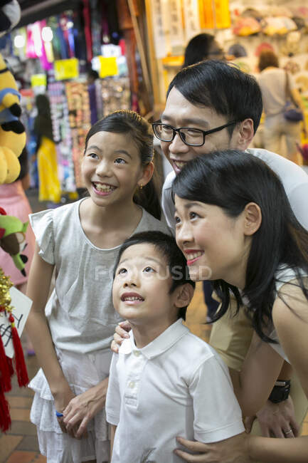 Family of four strolling through Singapore's Chinatown. — Stock Photo