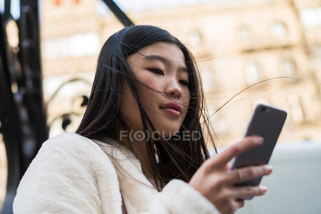 Молодая китаянка пользуется смартфоном в Барселоне — стоковое фото