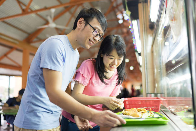 Jovem asiático casal juntos comer comida no rua café — Fotografia de Stock