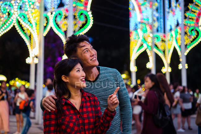 Young asian couple spending time together in city while celebrating christmas — Stock Photo