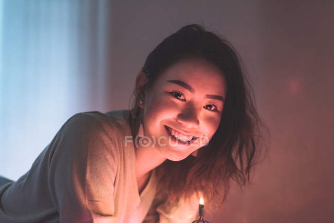 Giovane donna asiatica rilassante a casa con ghirlanda di Natale — Foto stock