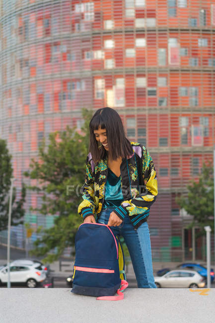 Молода приваблива азіатська жінка дивиться в рюкзак — стокове фото