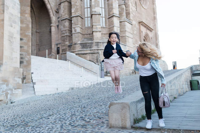 Jovem mãe feliz com sua filha se divertindo na cidade — Fotografia de Stock