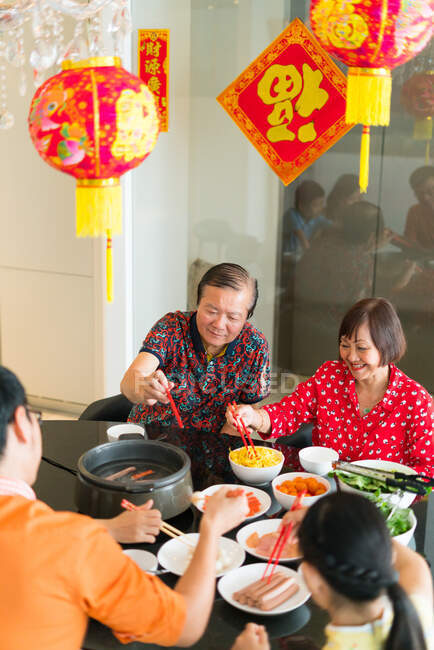 Счастливая азиатская семья едят вместе за столом — стоковое фото