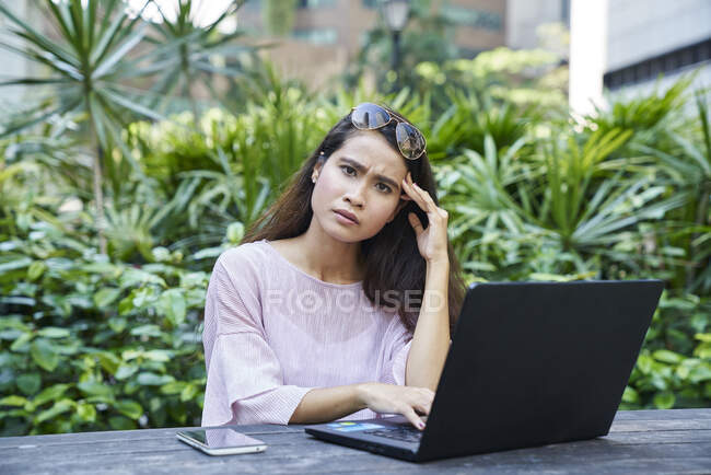 Joven mujer malaya frustrado mientras trabajaba en su computadora portátil - foto de stock