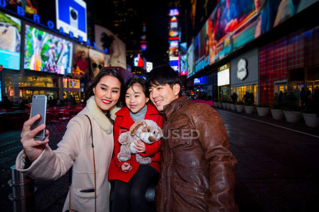 Glückliche Familie auf dem Times Square in New York. — Stockfoto