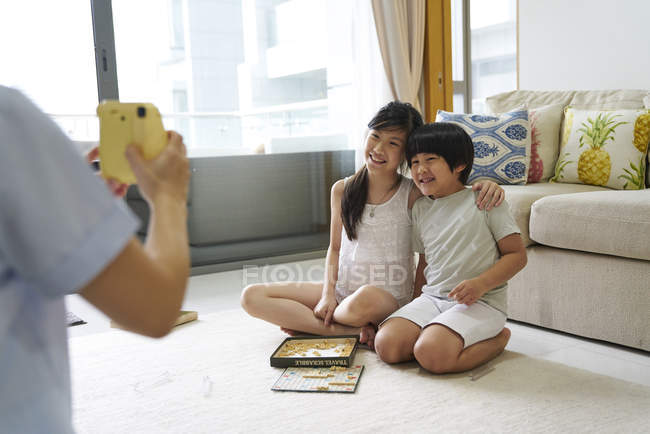 Feliz joven asiático familia juntos tomando foto en casa - foto de stock
