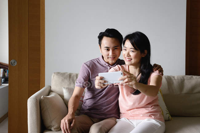 Adult asian couple together taking selfie at home — Stock Photo