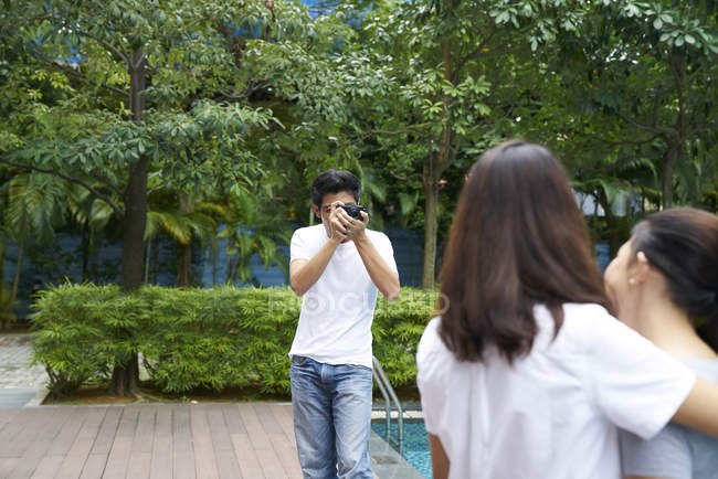 Fotógrafo tomando fotos de dos modelos en un resort - foto de stock