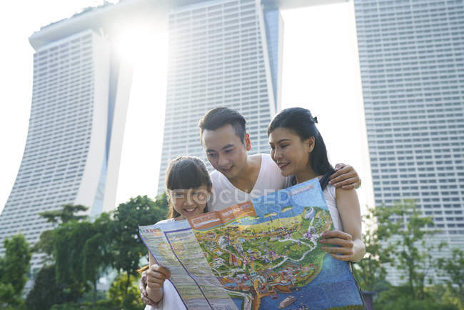 Familia explorando Jardines junto a la Bahía con un mapa en Singapur - foto de stock
