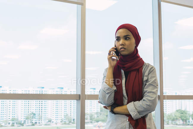 Успішна бізнес-леді розмовляє по телефону в сучасному офісі — стокове фото