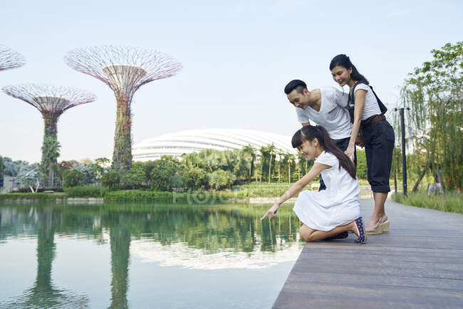 Familia curiosa sobre el lago en Gardens by the Bay, Singapur - foto de stock