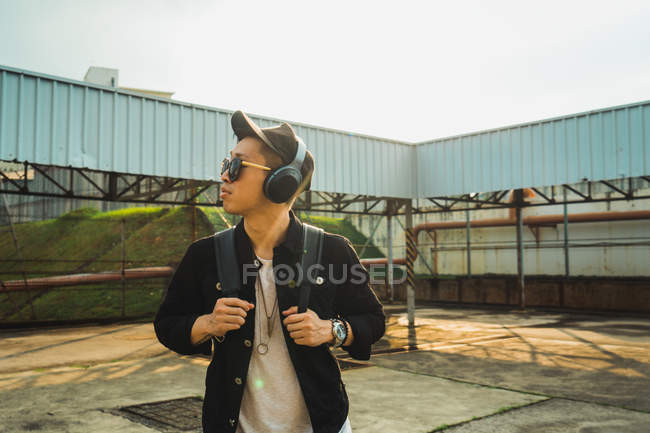 Молодой азиатский стильный мужчина в наушниках — стоковое фото