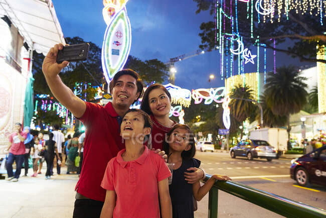 Famille joyeuse prenant selfies à Hari Raya Geylang Bazaar, Singapour — Photo de stock